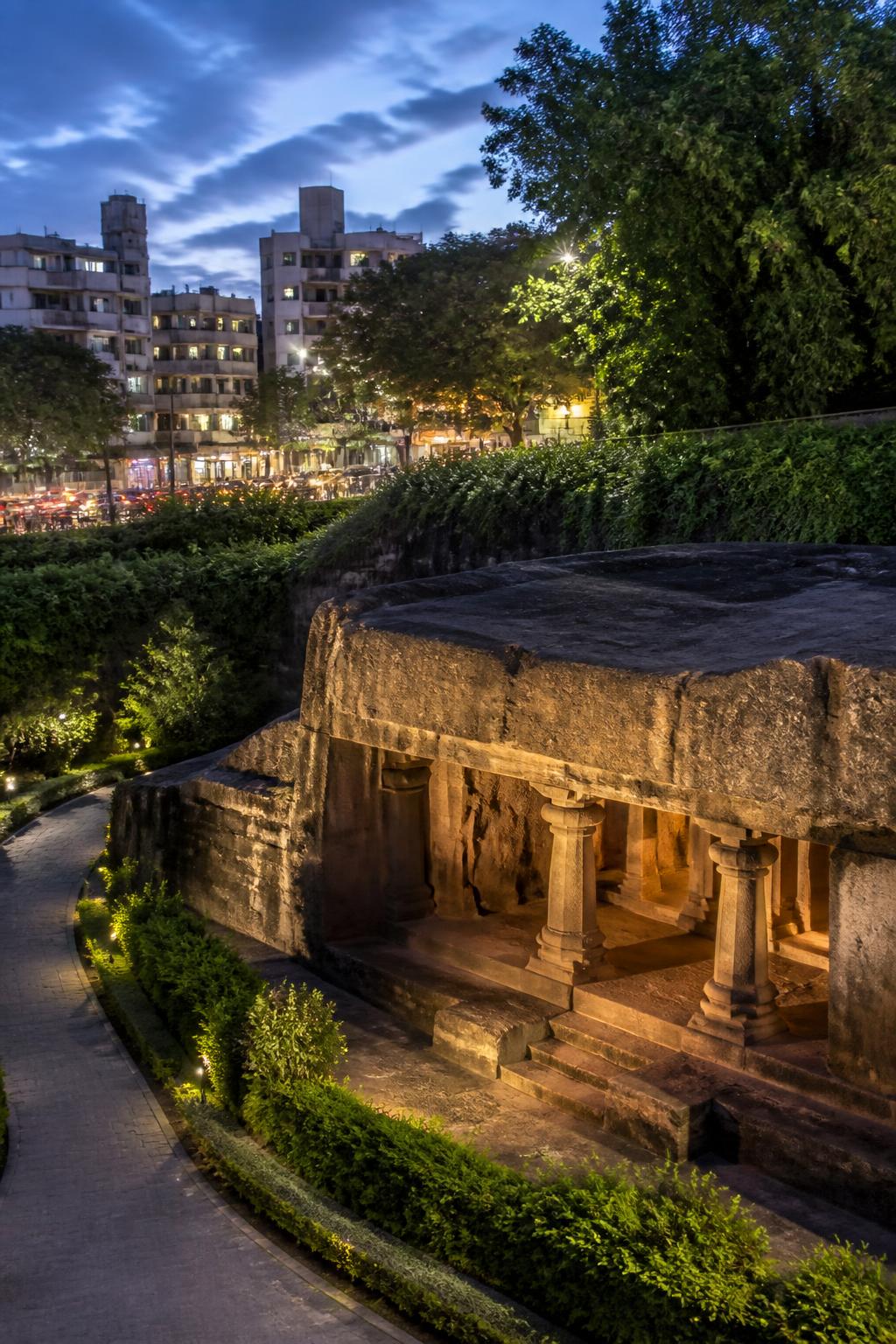 Pataleshwar Cave Temple stands amid modern Pune traffic and buildings.