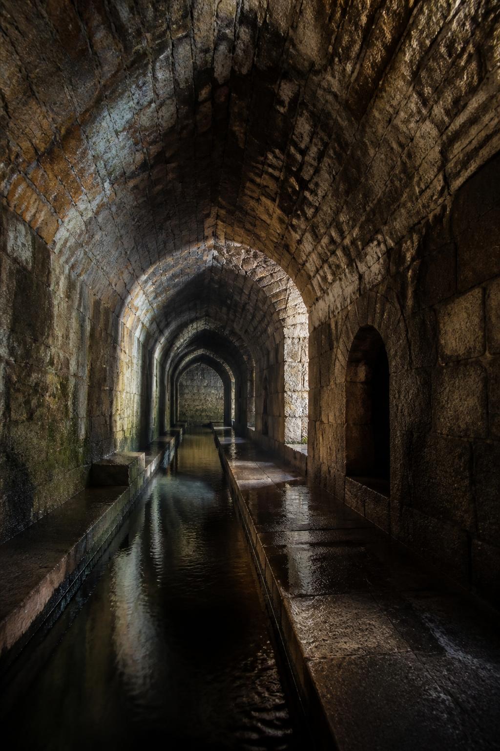 A walkable masonry tunnel representing Pune’s historic buried aqueduct.