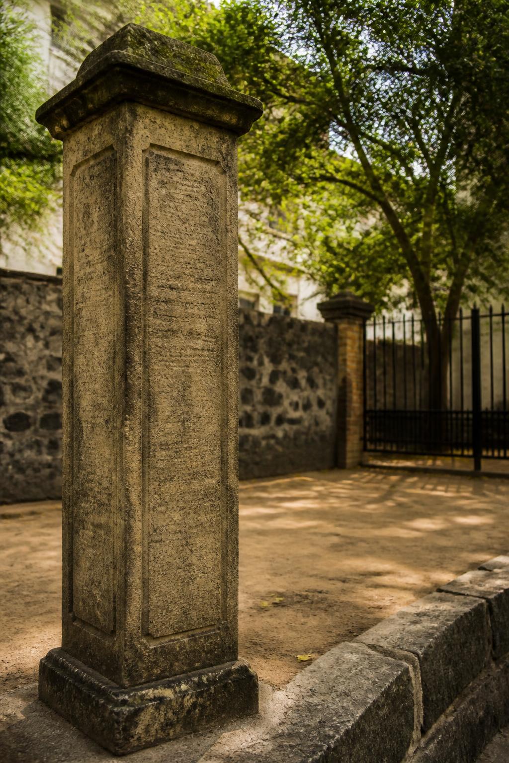 The surviving granite pillar, with multilingual inscriptions carved into its surface.