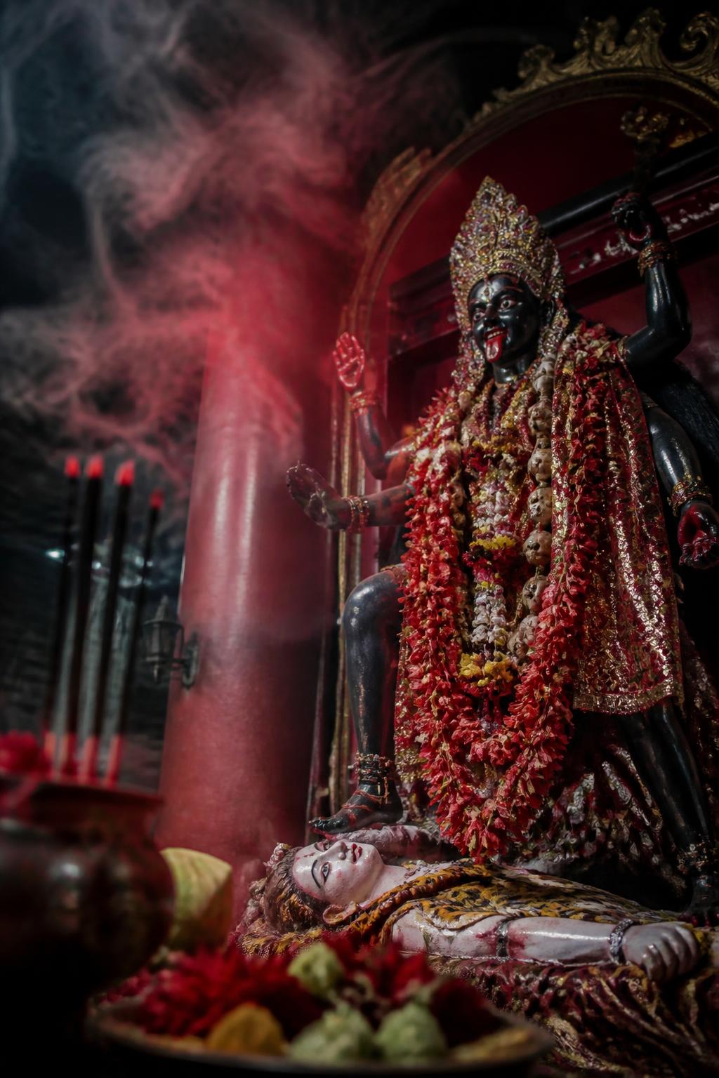Kali and Shiva devotional imagery with red incense at the temple.