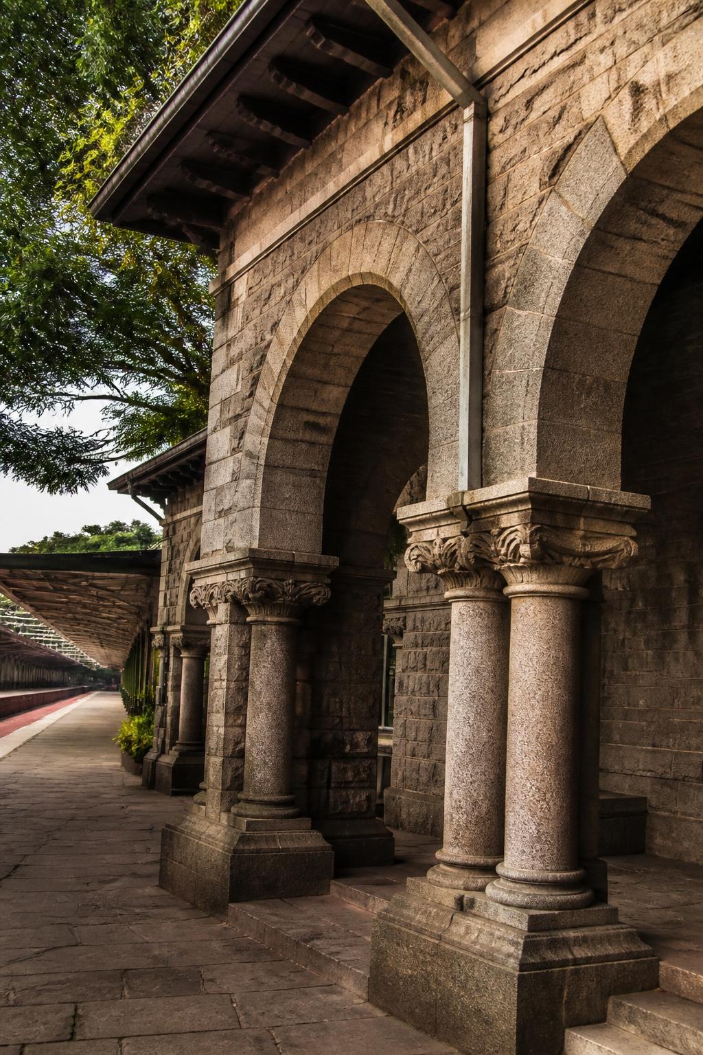 Colonial-era stone arches and platform shelter at Bengaluru Cantonment station.